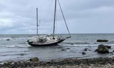 Firefighters helped two men and a woman back to shore after the sailboat they were on ran aground off the coast of Massachusetts.