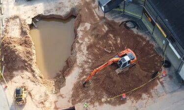 The sinkhole in front of a business plaza on Sardis Road as seen from above.