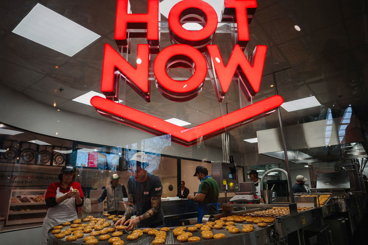 <i>Dimitar Dilkoff/AFP/Getty Images</i><br/>Krispy Kreme workers prepare donuts in the firm's first store in France on December 4.