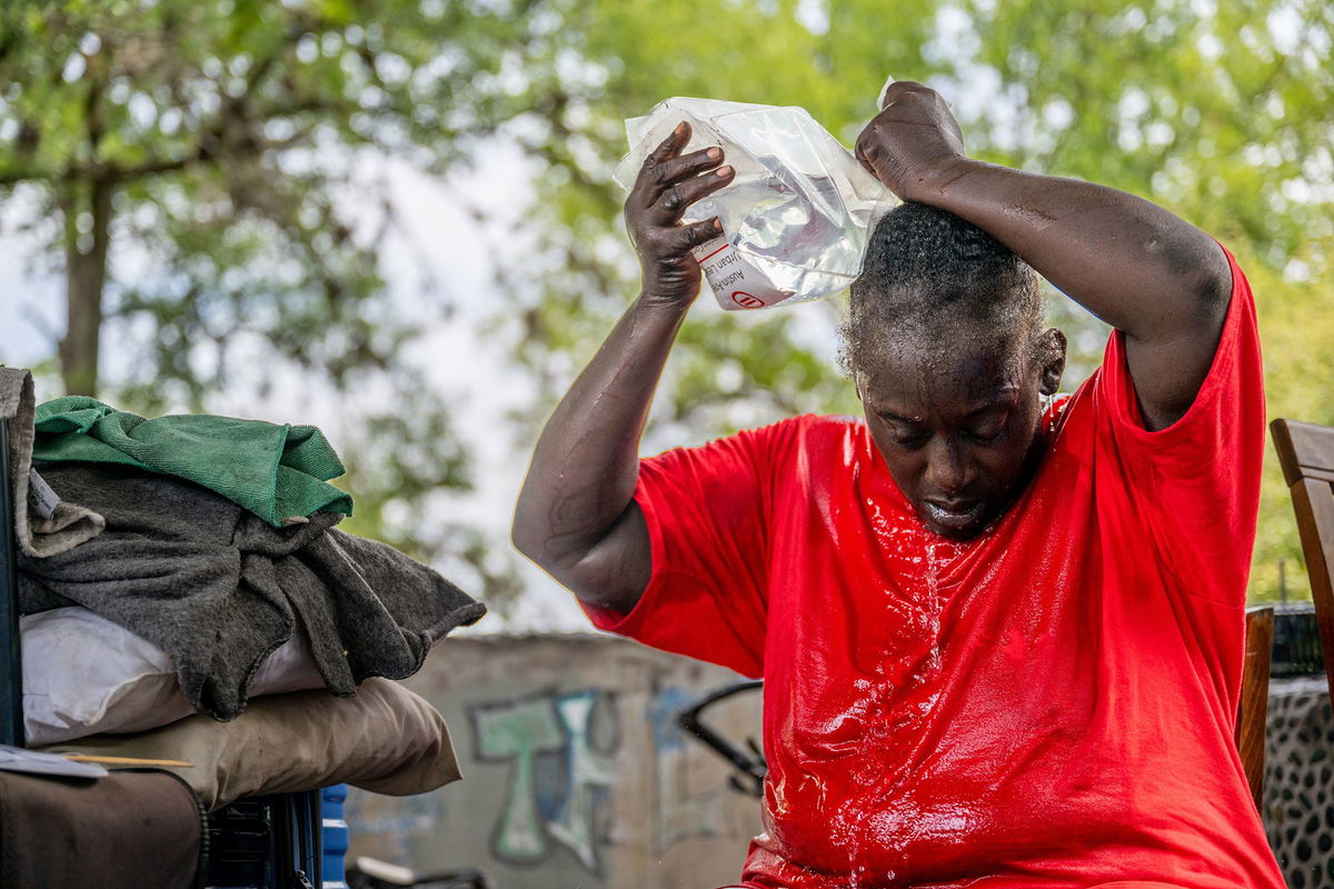 Andrea Washington pours water on herself in the Hungry Hill neighborhood on July 11, 2023 in Austin, Texas.