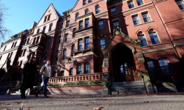 Passers-by walk on the campus of Harvard University