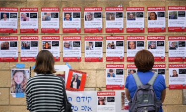 People look at photographs of some of those taken hostage by Hamas in Tel Aviv