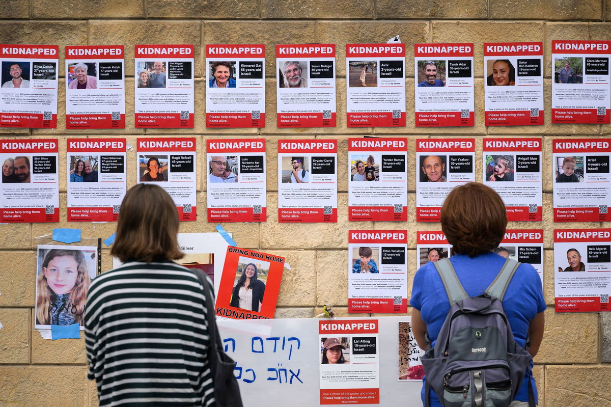 <i>Leon Neal/Getty Images/FILE</i><br/>People look at photographs of some of those taken hostage by Hamas in Tel Aviv