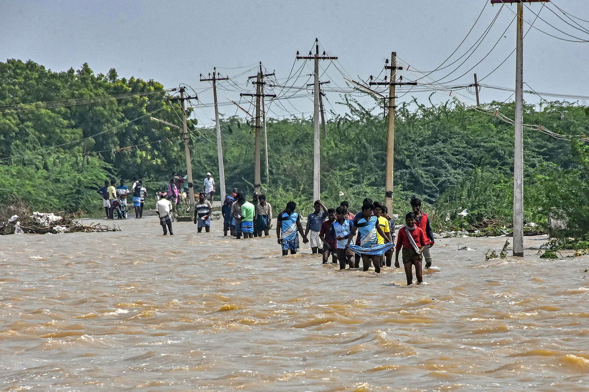 <i>Stringer/AFP/Getty Images</i><br/>People wade through a flooded road after heavy rains in Thoothukudi on December 20.