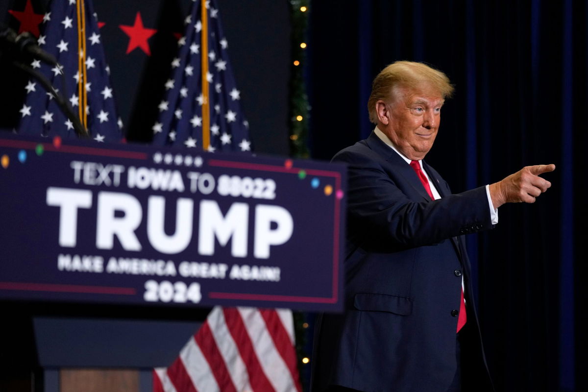 <i>Charlie Neibergall/AP</i><br/>Former President Donald Trump greets supporters as he arrives at a commit to caucus rally