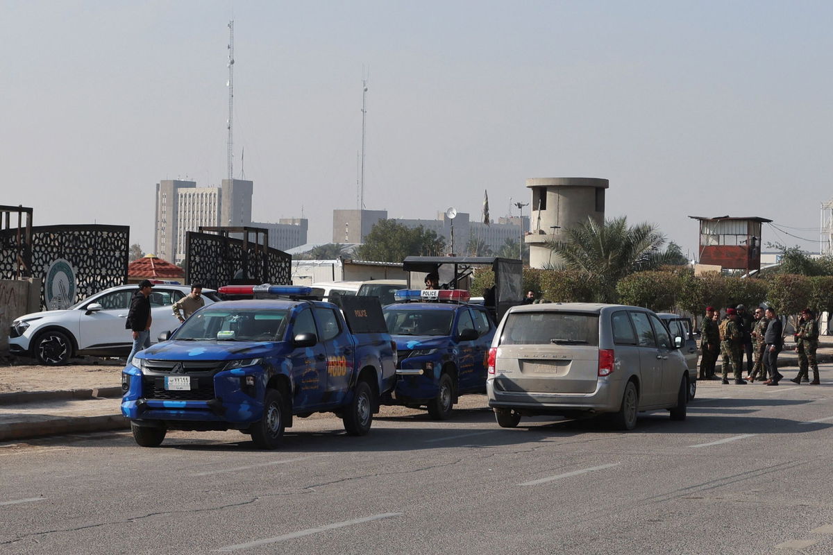 <i>Ahmed Saad/Reuters</i><br/>Iraqi security forces stand guard at a street after an attack by a drone strike on an Iran-backed militia headquarters in Baghdad