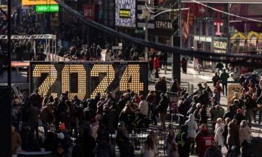 People gather December 20 around the 2024 New Year's Eve numerals displayed in Times Square in New York.