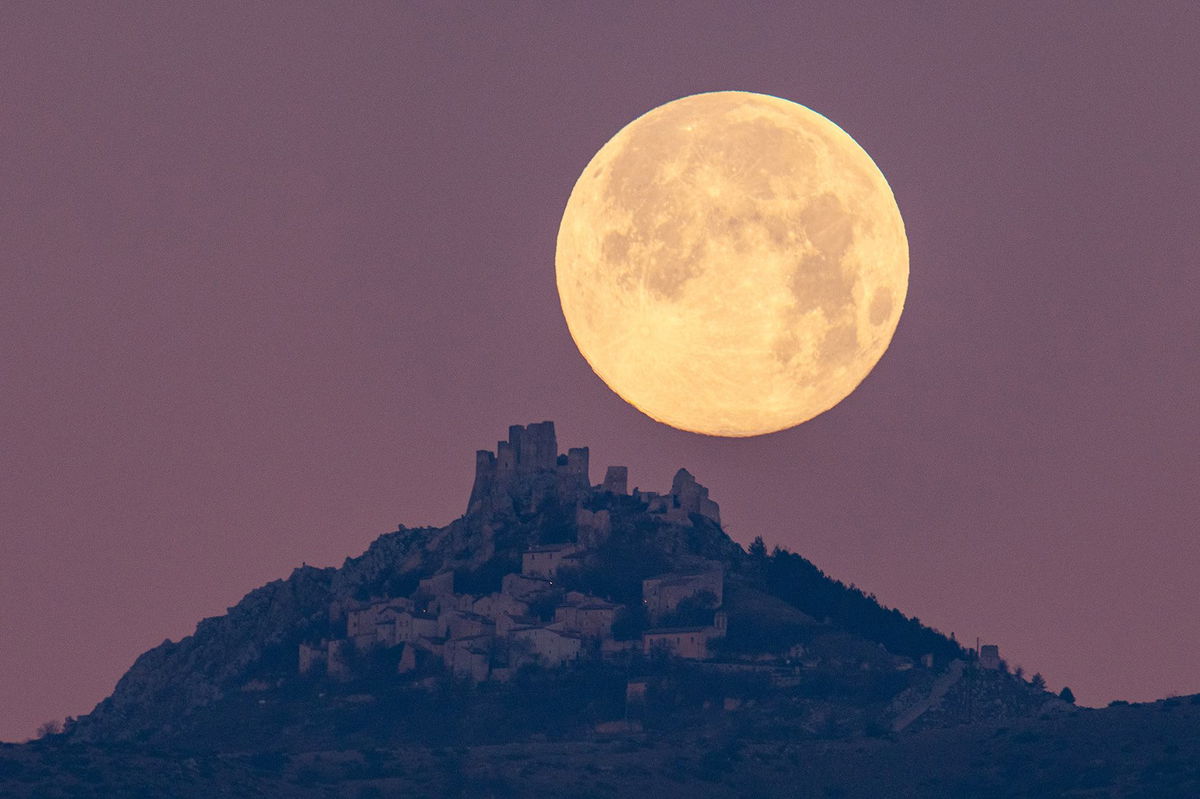 The wolf moon can be seen setting behind the castle of Rocca Calascio in the Abruzzo region of Italy, on January 7, 2023.