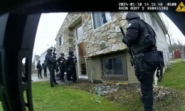 A body-worn camera footage still shows Elyria Police Department officers gathered outside a home during a raid on January 10.
