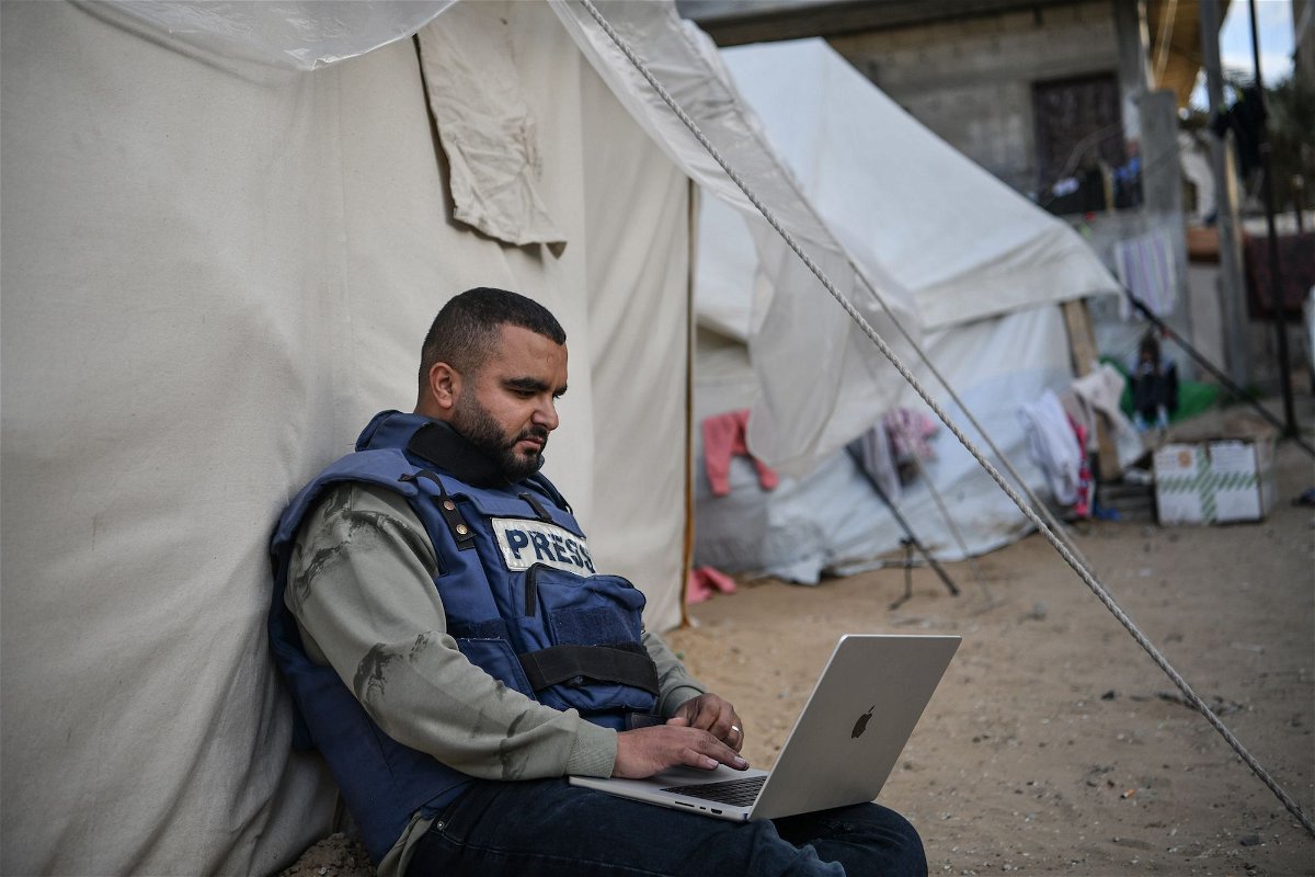 <i>Abed Zagout/Anadolu Agency/Getty Images</i><br/>A press member is seen sitting next to a tent as he tries to connect to the internet while he and his colleagues in Gaza face high risks trying to cover the Israel-Gaza war on January 14 in Rafah