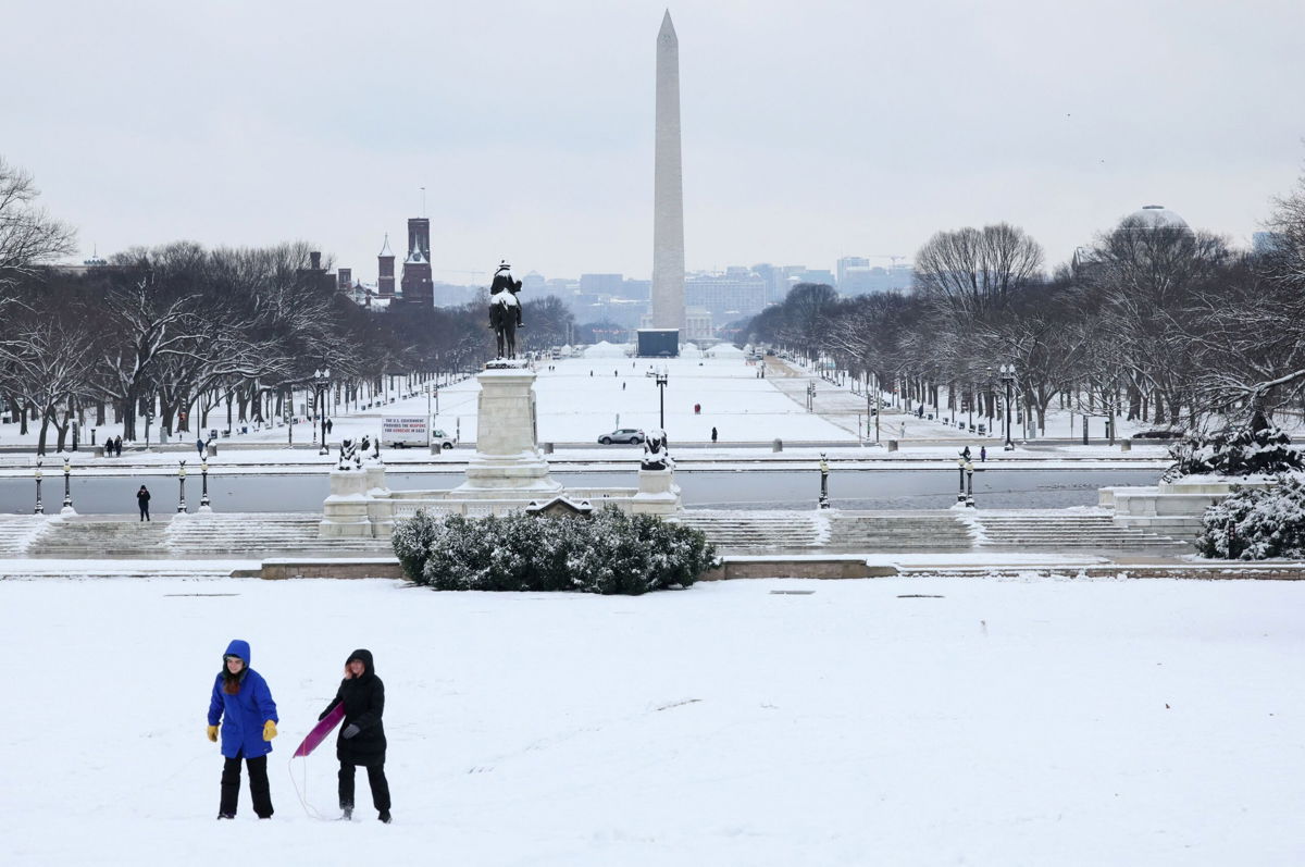 <i>Jessica Kourkounis/Getty Images</i><br/>Pedestrians walk through snow and high winds on March 21