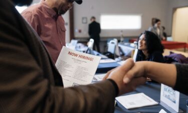 Attendees shake hands at a Veteran Employment and Resource Fair in Long Beach