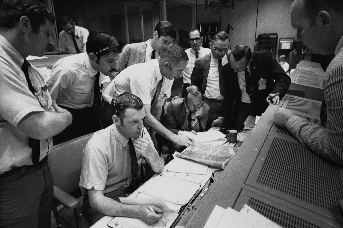 Flight controllers gather around NASA Flight Director Glynn Lunney (seated, foreground) in the control room at what's now called Johnson Space Center in Houston during the Apollo 13 aborted lunar landing mission, on April 15, 1970.