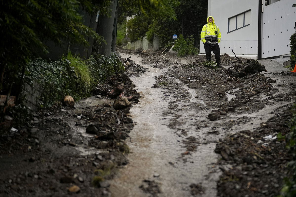 A first responder stands atop a hill in the aftermath of a mudslide, Monday, Feb. 5, 2024, in the Beverly Crest area of Los Angeles.