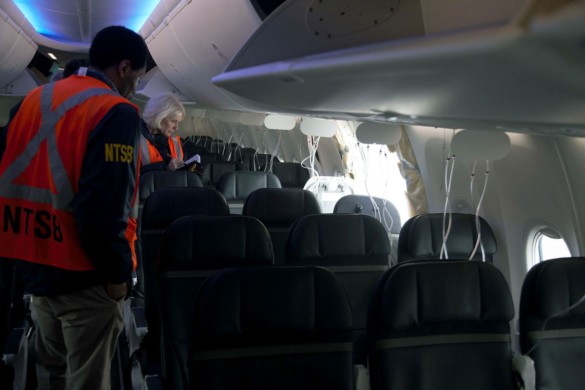 <i>NTSB/Handout/Getty Images</i><br/>Members of the NTSB examine the hole in the fuselage plug area of Alaska Airlines Flight 1282.