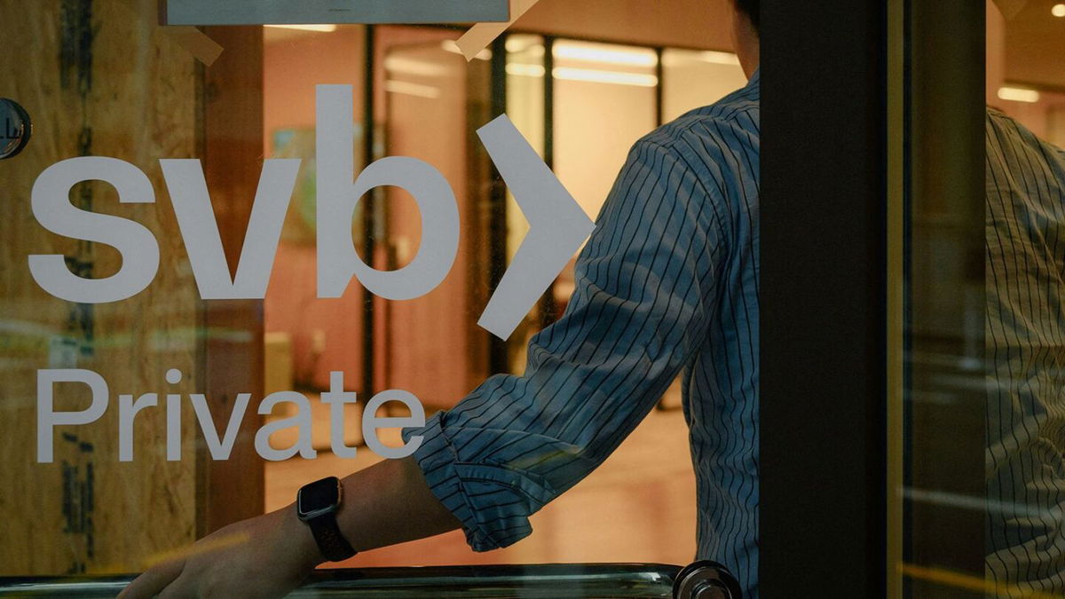 An employee holds the door open at the Silicon Valley Bank branch office in downtown San Francisco, California, in March 2023.