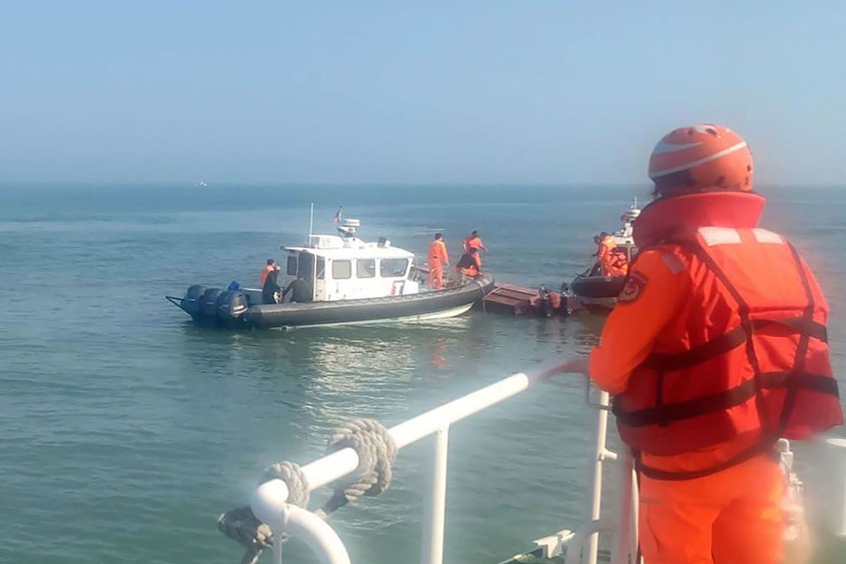 The Taiwan coast guard inspect a vessel that capsized during a chase off the coast of Kinmen island in Taiwan on Feb. 14, 2024.