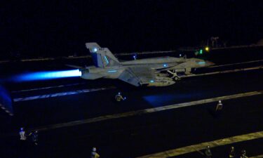 An F/A-18 with afterburner prepares to launch from the deck of the USS Dwight D. Eisenhower aircraft carrier in the Red Sea.