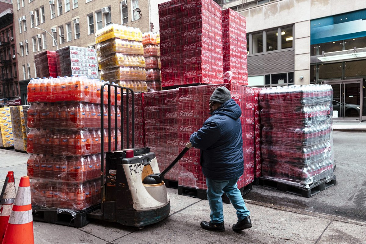 A worker moves pallets of soft drinks outside a beverage distribution company in New York on January 29, 2024.