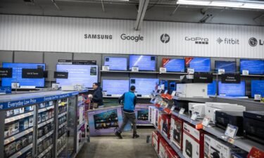 A worker stocks televisions at a Walmart store on Black Friday in Secaucus