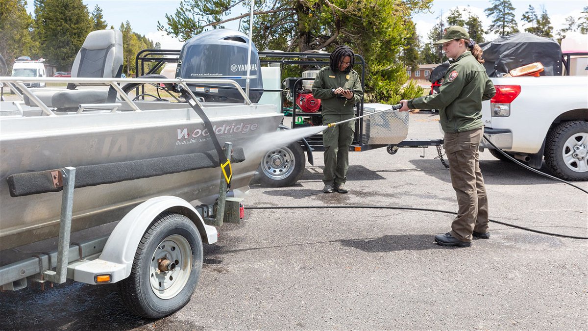 AIS technicians decontaminating a motorized boat and trailer