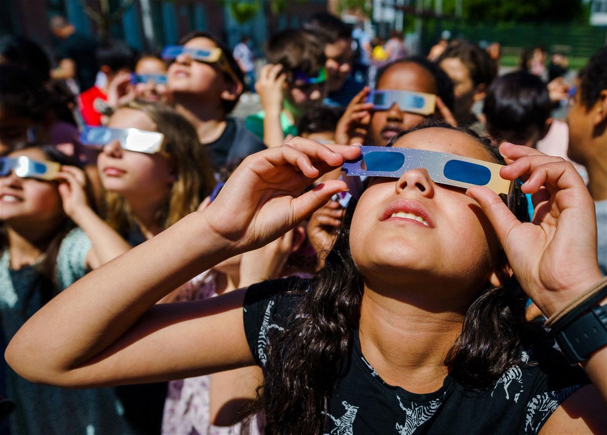 <i>Marco de Swart/ANP/AFP/Getty Images via CNN Newsource</i><br/>Students wear protective glasses to view a partial solar eclipse over Schiedam
