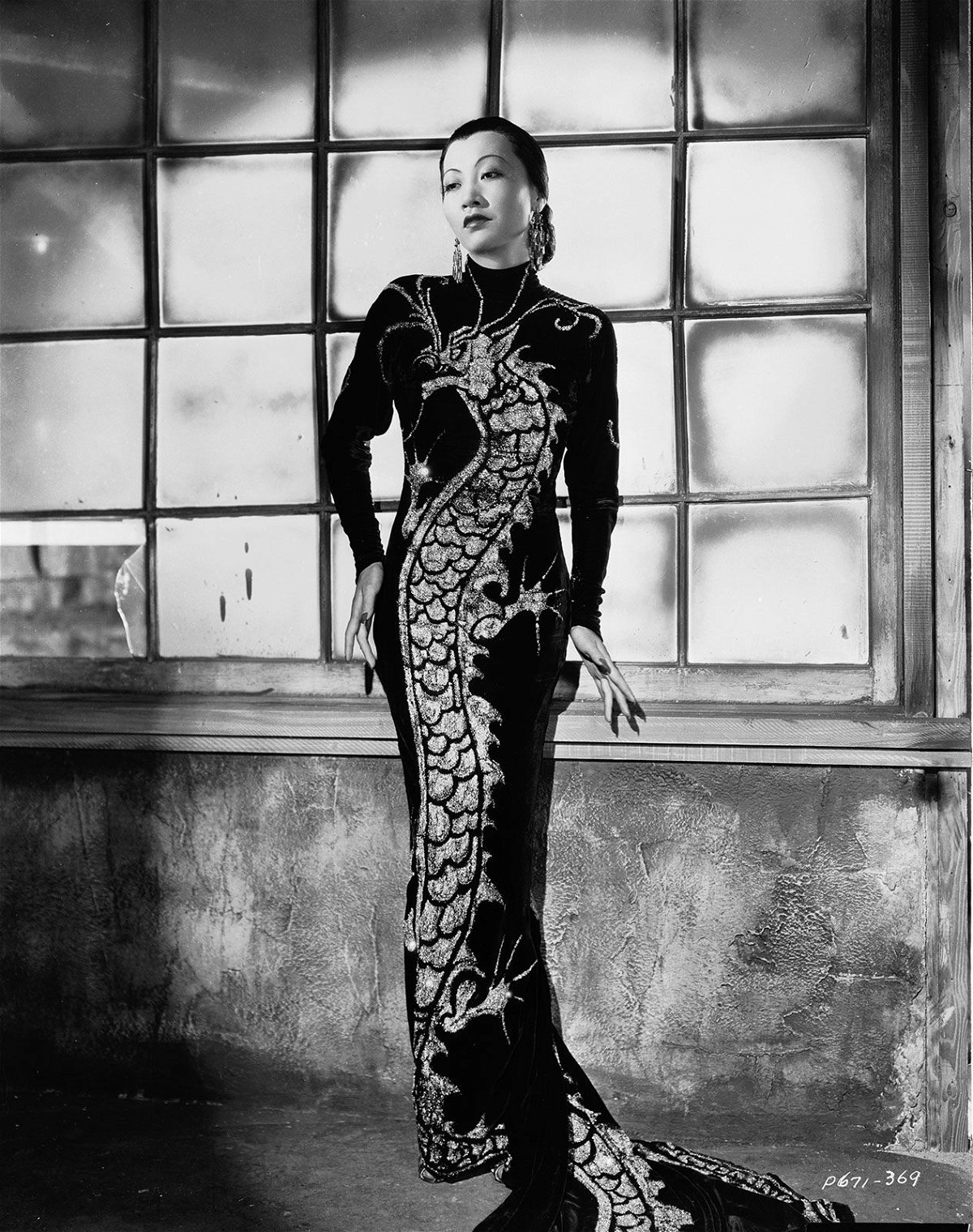 Anna May Wong wears a dress with a dragon motif in 1934.