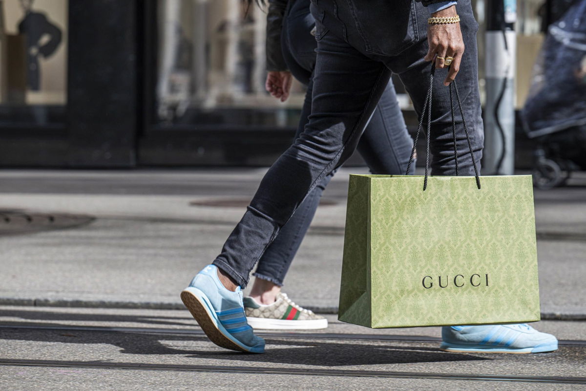 A shopper carries a Gucci shopping bag in central Zurich, Switzerland, on Saturday, March 16.