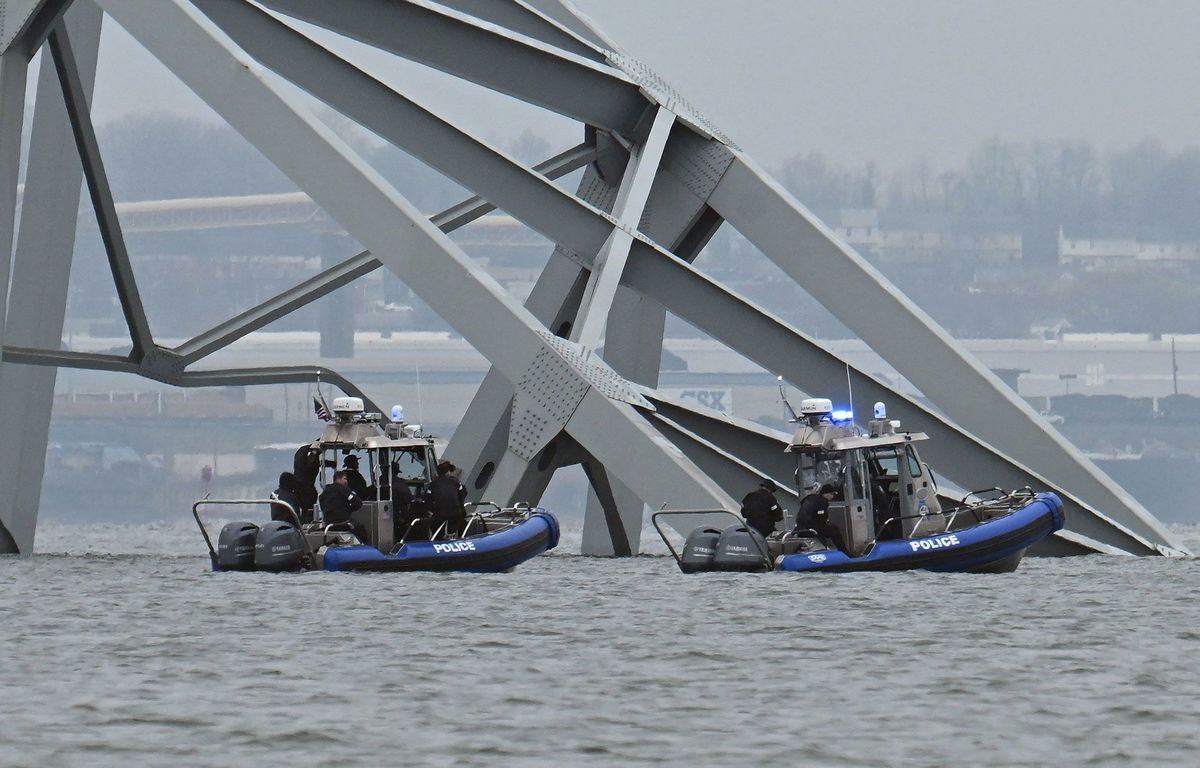 Police recovery crews work near the collapsed bridge.