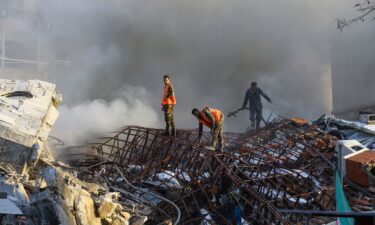 Emergency personnel extinguish a fire at the site of strikes which hit a building next to the Iranian embassy in Syria's capital Damascus on Monday