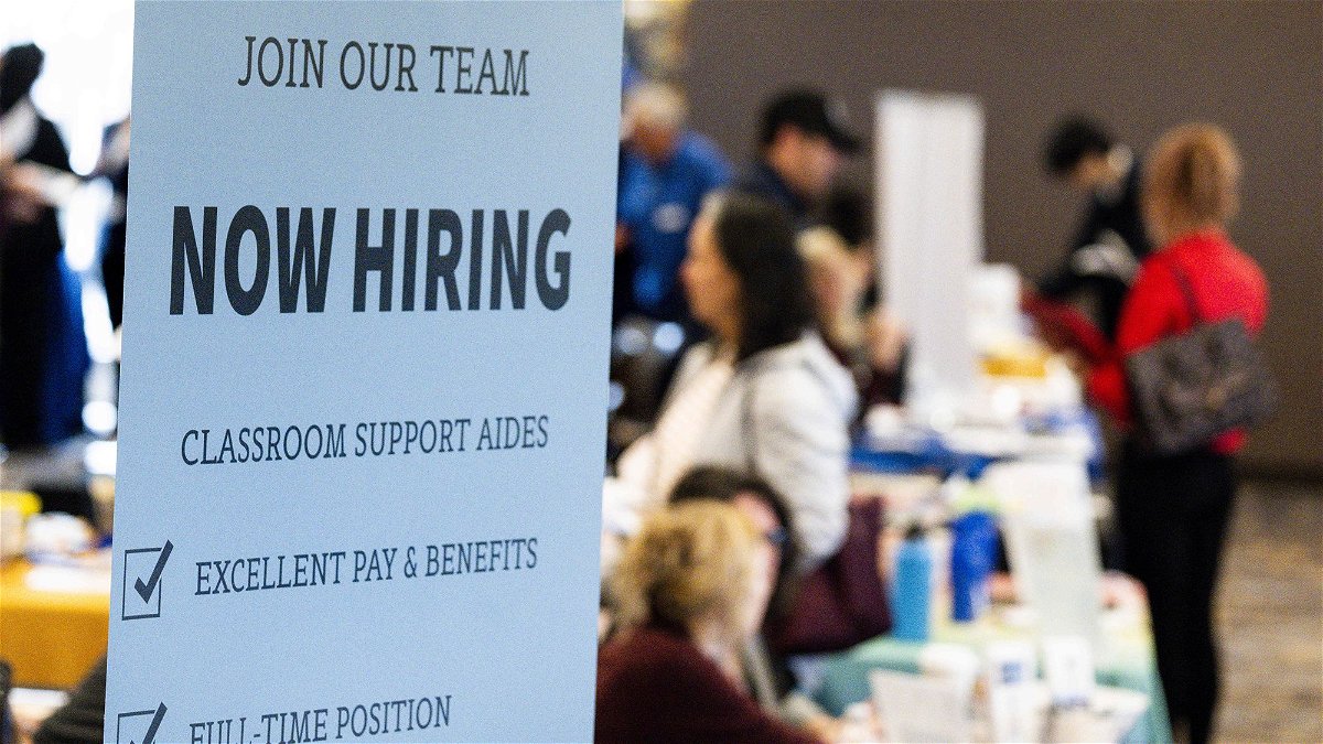 Employers take resumes and talk to prospective new hires at a career fair in Lake Forest