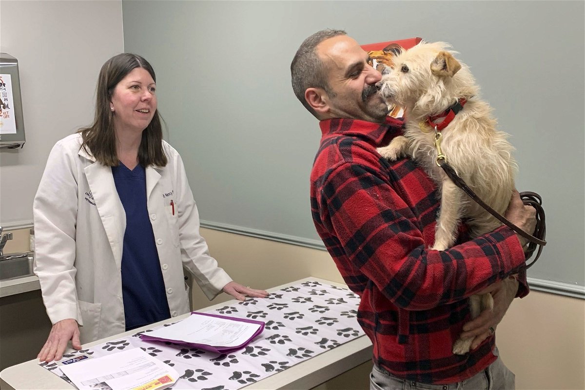 <i>Corinne Martin/AP via CNN Newsource</i><br/>Mehrad Houman of San Diego holds Mishka after the dog was examined Friday by veterinarian Nancy Pillsbury in Harper Woods