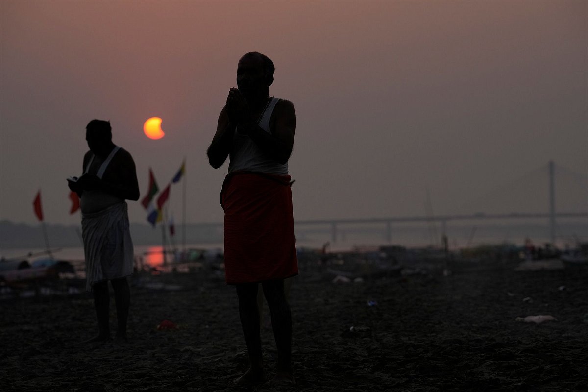 Hindu devotees in Prayagraj in the northern Indian state of Uttar Pradesh perform rituals during the partial solar eclipse on October 25, 2022.