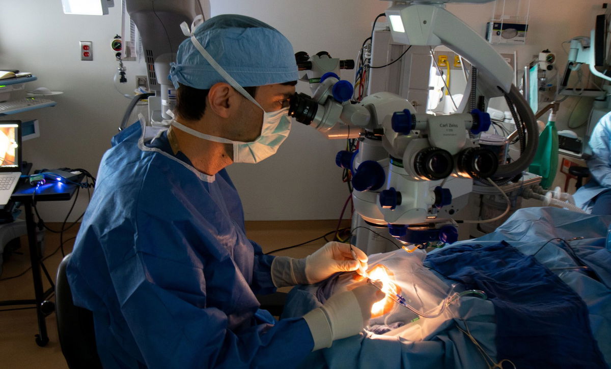 Dr. Jason Comander performs the surgical procedure to deliver experimental CRISPR-based medicine to a trial participant in September 2020.