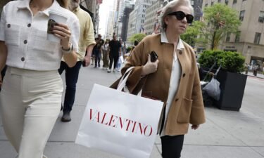 People walk along Fifth Avenue with shopping bags on May 8 in New York City. Inflation cooled back down in April