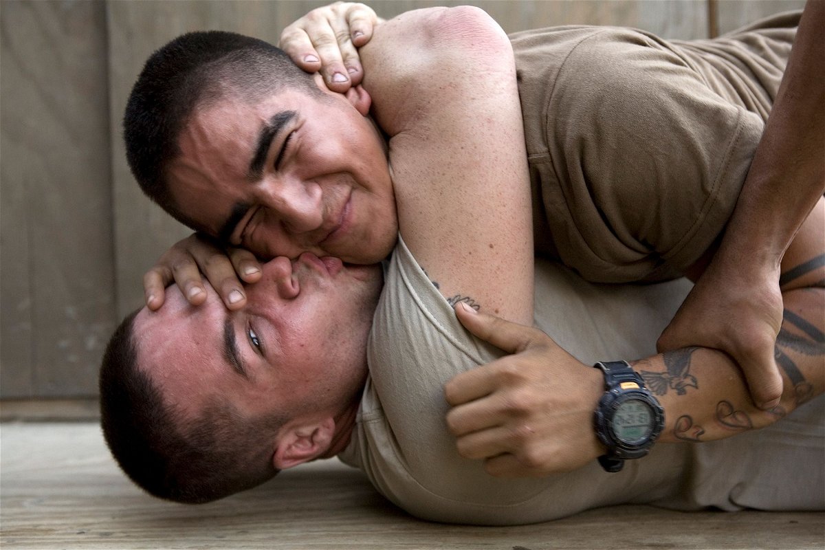 Bobby kisses Cortez udring a play fight at the barracks of Second Platoon at the Korengal Outpost in Afghanistan in June 2008.