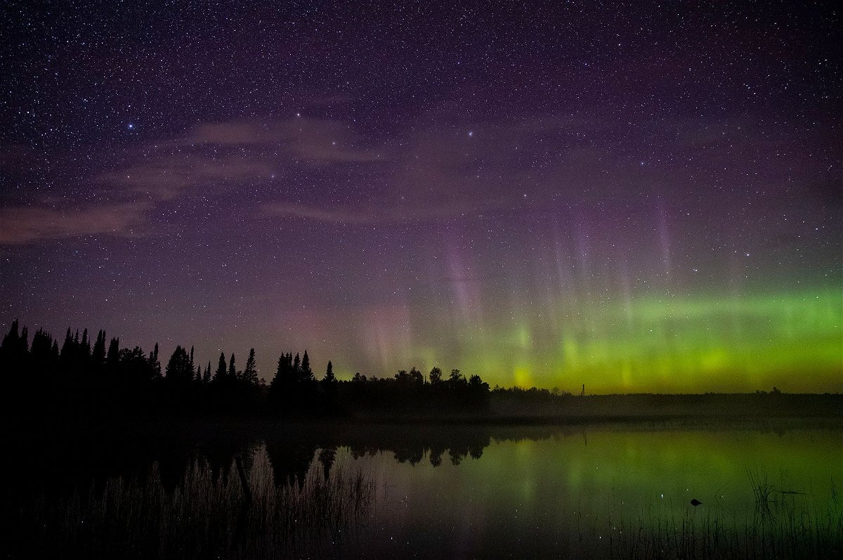 The aurora borealis can be seen on the north horizon in the night sky over Wolf Lake in the Cloquet State Forest in Minnesota in September 2019.