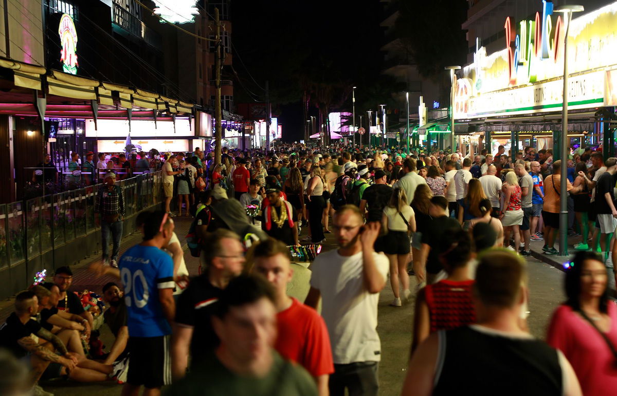 Crowds gather on a June 2023 evening on a busy street in Palma de Mallorca, Spain. Spain’s Balearic Islands are further cracking down on public drinking and party boats.