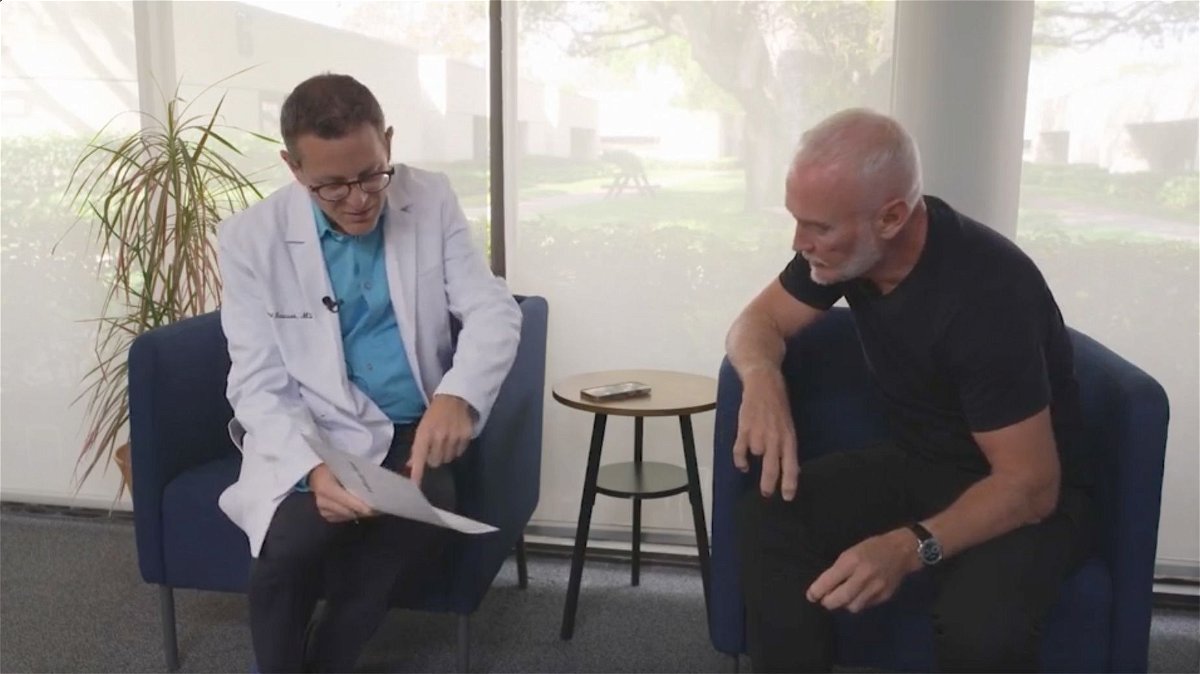 Dr. Richard Isaacson, left, discusses test results with Simon Nicholls, participant No. 34 in his clinical trial.