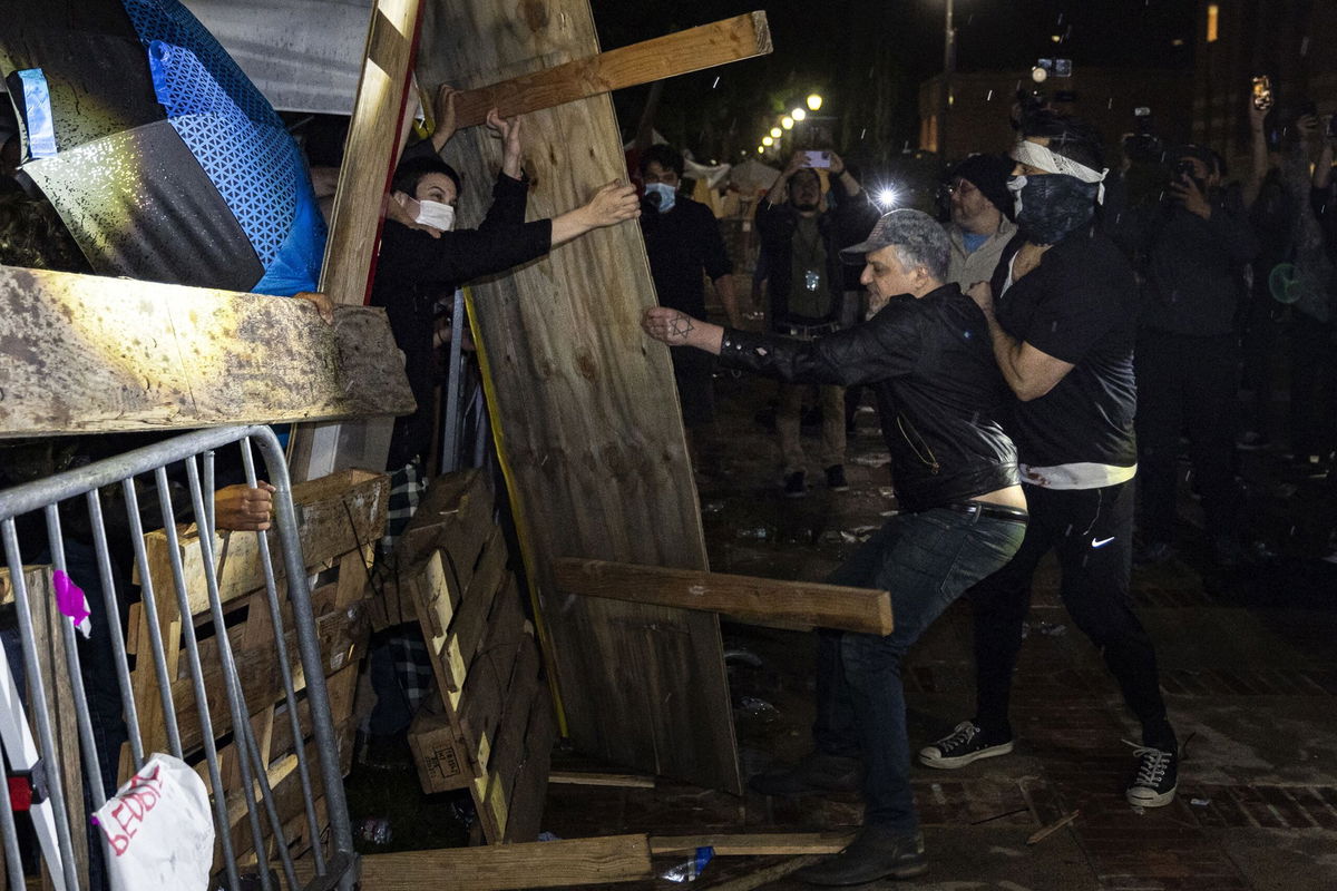 <i>Etienne Laurent/AFP/Getty Images via CNN Newsource</i><br/>Counterprotesters attack a pro-Palestinian encampment set up on the campus of the University of California Los Angeles on May 1