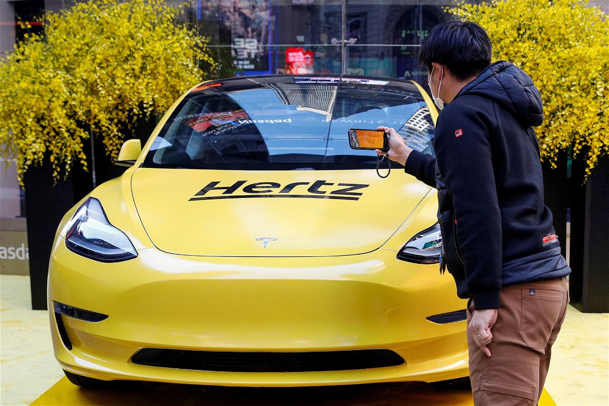 <i>Brendan McDermid/Reuters via CNN Newsource</i><br/>A man photographs a Hertz Tesla electric vehicle displayed in Times Square in New York City