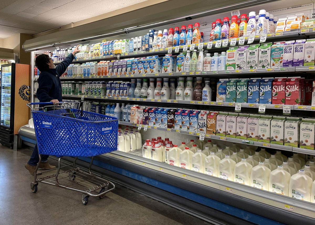 <i>Justin Sullivan/Getty Images via CNN Newsource</i><br/>A customer shops for milk at a grocery store in December 2023 in San Anselmo