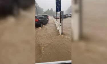 Part of Dollywood's parking lot can be seen flooded as cars try to exit the grounds