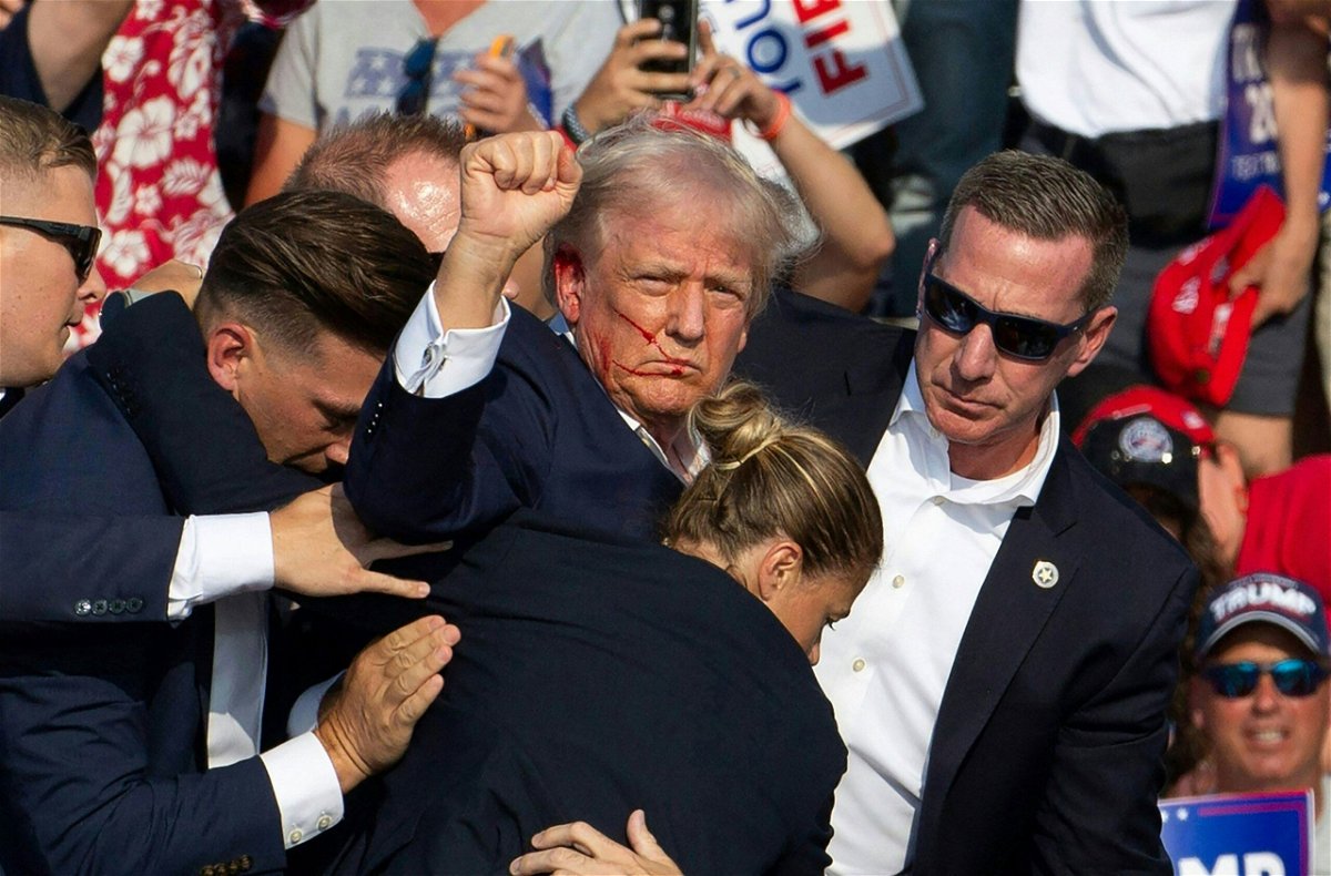 <i>Rebecca Droke/AFP via Getty Images via CNN Newsource</i><br/>Former President Donald Trump is escorted offstage by Secret Service agents after a gunman opens fire at him at a Pennsylvania rally last weekend.