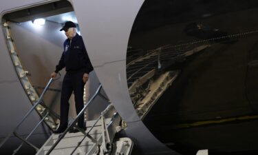 President Joe Biden gestures to reporters as he steps off Air Force One upon arrival at Dover Air Force Base in Dover