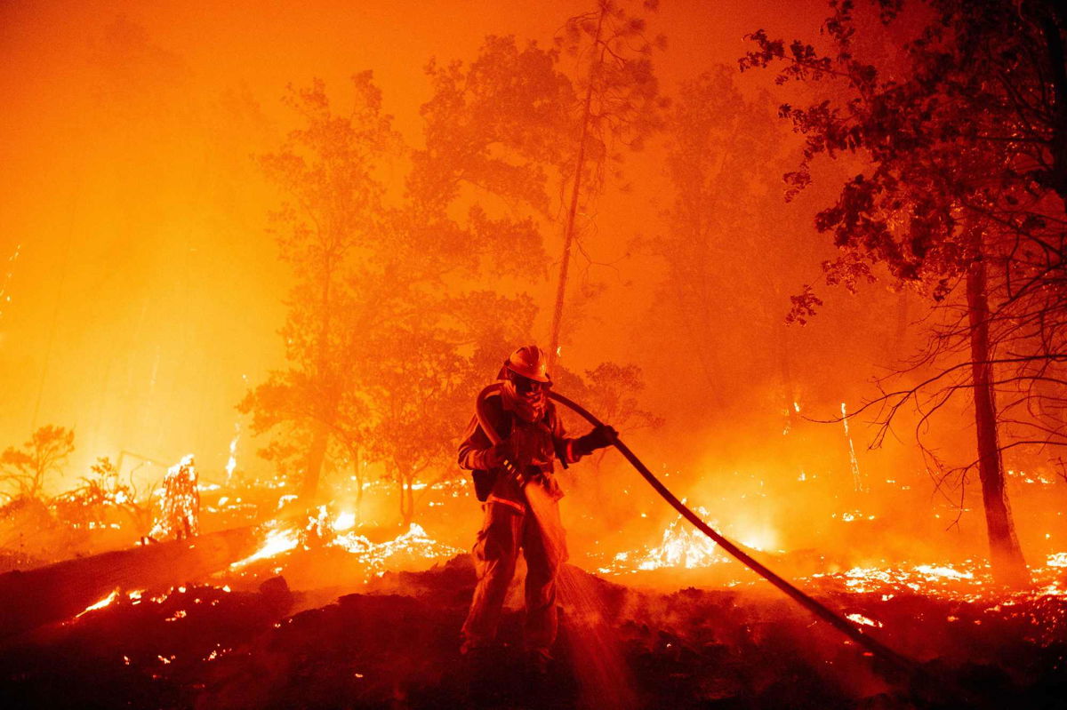 <i>Josh Edelson/AFP/Getty Images/File via CNN Newsource</i><br/>A firefighter douses flames as they push towards homes during the Creek fire in the Cascadel Woods area of unincorporated Madera County