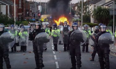 Riot police hold back protesters after disorder broke out on July 30