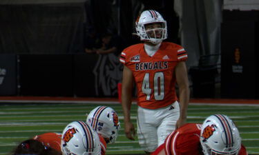 An Idaho State football player prepares to kick a field goal.