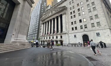 People pass the New York Stock Exchange on August 28.