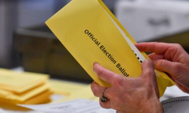 Wake County Board of Elections member Keith Weatherly signs a box of mail-in ballots at the Wake County Board of Elections ballot processing center in Raleigh